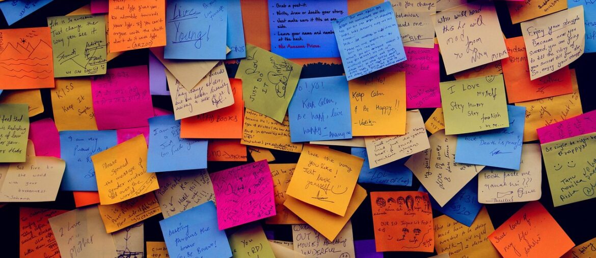 Bunte Post its mit Notizen an einer Wand